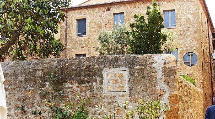 Stone building front with shuttered windows on a narrow town street