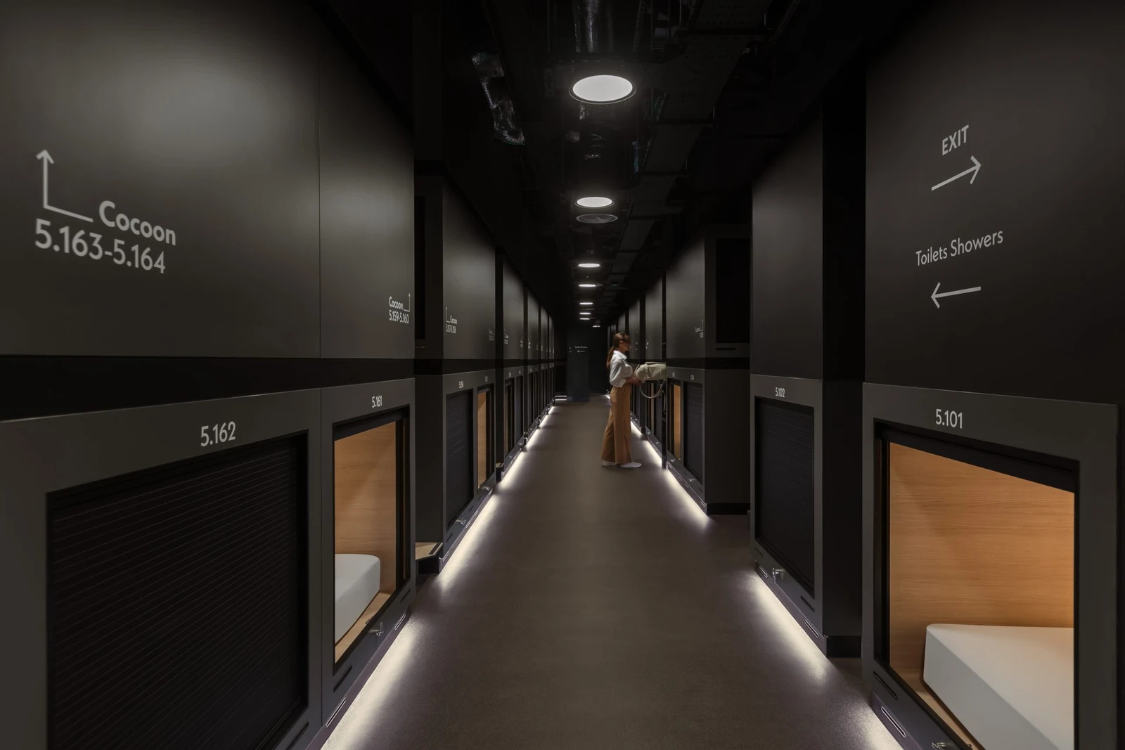 Row of compact sleeping berths stacked along a narrow corridor