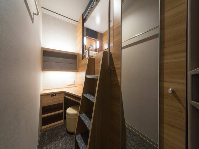 Interior corridor lined with stacked compact sleeping cabins