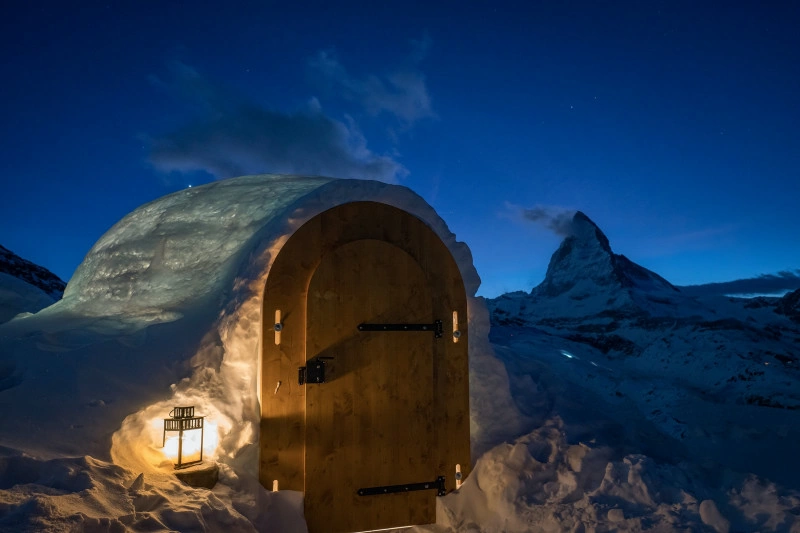 Cluster of rounded snow domes on open high ground in low light