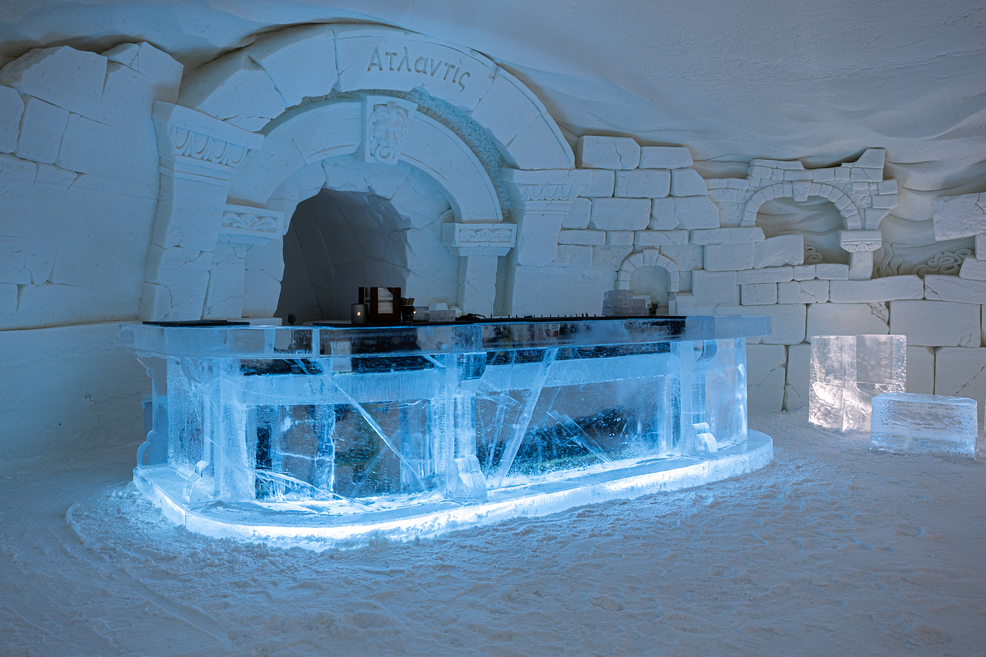 Hall of packed snow with carved wall panels and a block of clear ice